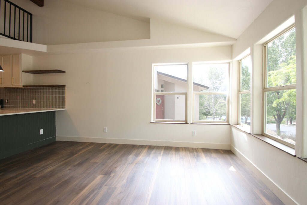 Empty staged living room photographed from the corner, the way listing photos hide flow problems