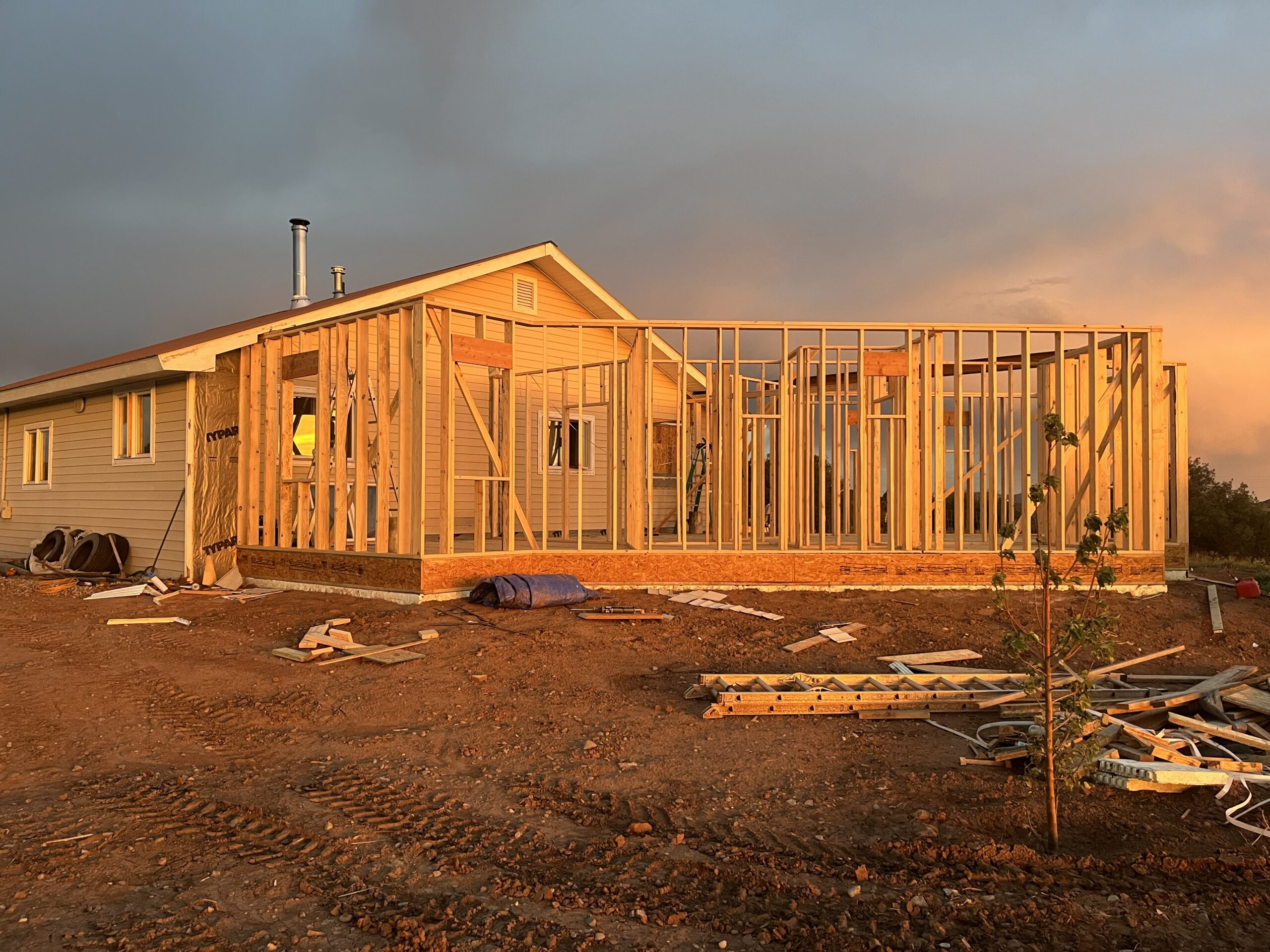 Home addition under construction, new framing connecting to an existing house